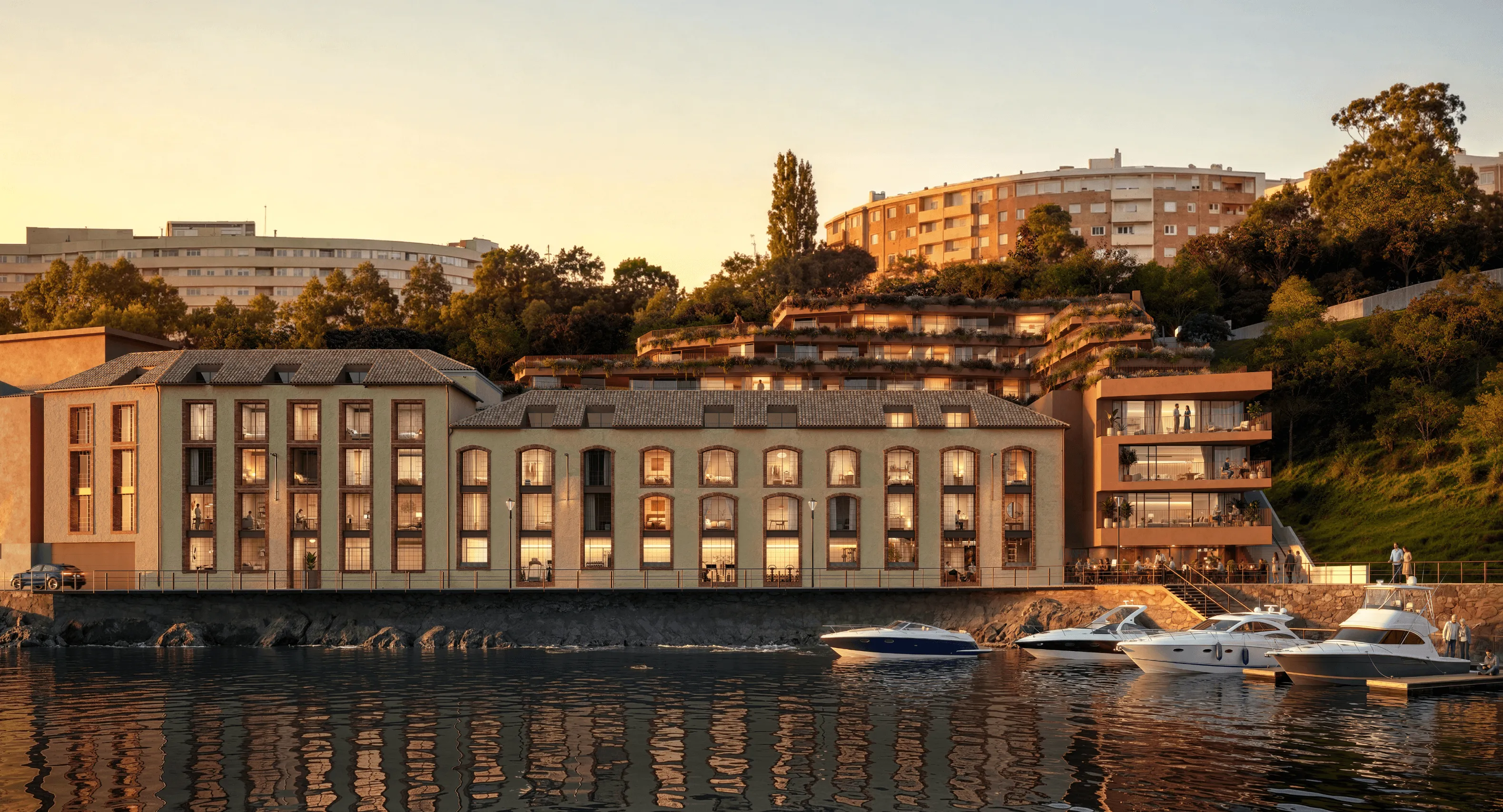 Waterfront residential buildings with large windows, green rooftop terraces, and balconies overlooking a marina with luxury yachts, surrounded by lush trees and warm golden sunset light.